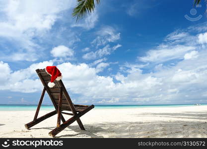 Santa&acute;s hat and chaise lounge on the beach