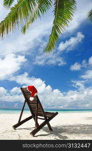 Santa&acute;s hat and chaise lounge on the beach