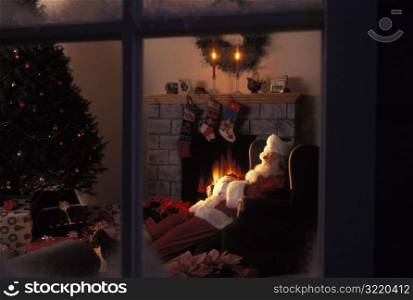 Santa Claus Asleep In Front Of Fireplace
