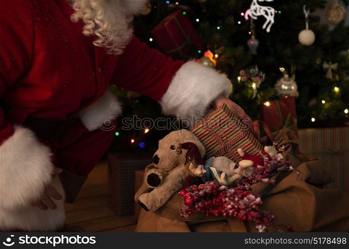 Santa Claus at Home putting gifts under Christmas Tree