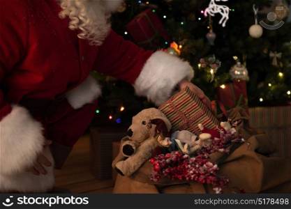 Santa Claus at Home putting gifts under Christmas Tree