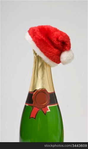 Santa Claus cap on a bottle of champagne