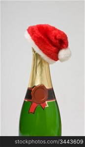 Santa Claus cap on a bottle of champagne