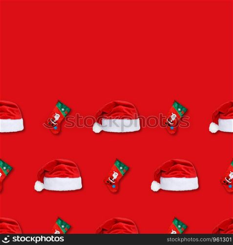 Santa Claus christmas red hat and christmas sock isolated on red background. Christmas seamless pattern. Copy space.
