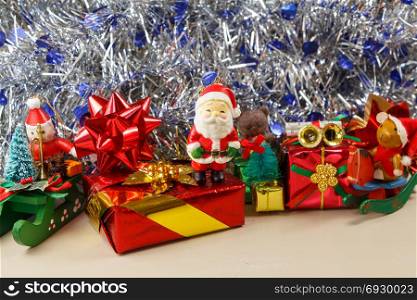 Santa Claus figurine with gifts and blue and silvery tinsel as decoration for Christmas