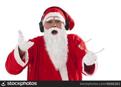 Santa Claus gesturing while listening to music over white background