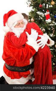 Santa Claus getting a big hug from a child on Christmas morning. White background.