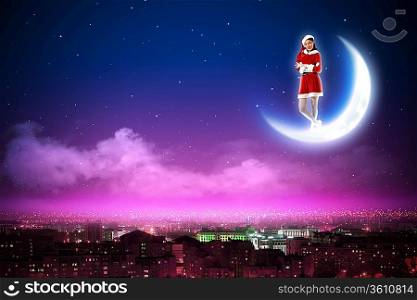 Santa Claus girl on the moon above a city at night