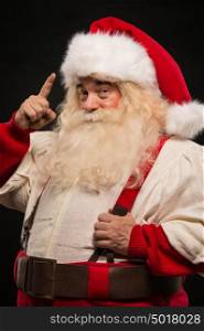 Santa Claus have an idea gesturing with finger against dark background