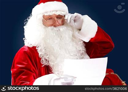 Santa Claus holding and reading a letter to him