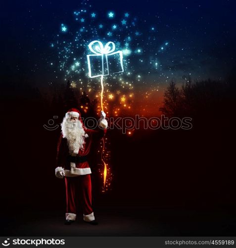 Santa Claus. Image of Santa Claus with present against dark background