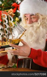 Santa Claus in his workshop making new toys for Christmas Presents for children around the world