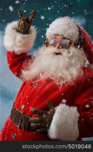Santa Claus is listening to music in headphones outdoors at North Pole, Having fun while delivering gifts