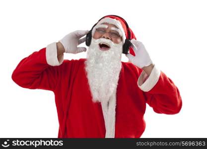 Santa Claus laughing while listening to music from headset over white background