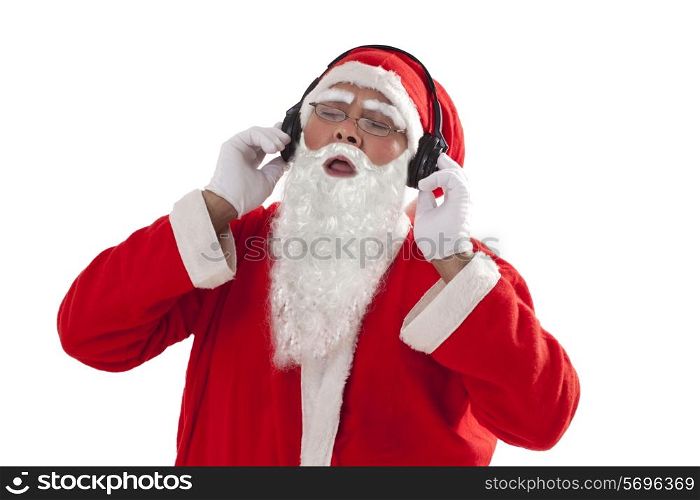 Santa Claus listening to music from headphones over white background