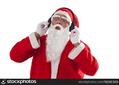 Santa Claus listening to music from headphones over white background