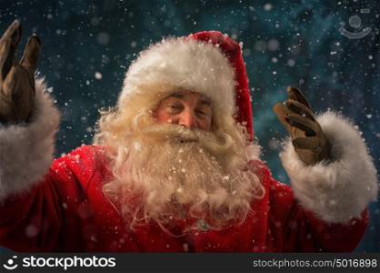 Santa Claus making magic at night under snow outdoors