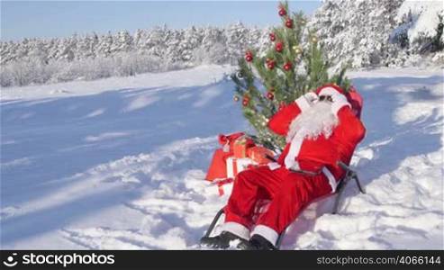 Santa Claus near Christmas tree enjoying frosty sunny day in snow covered winter forest