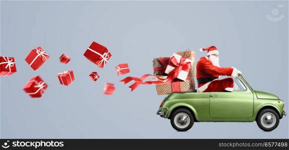 Santa Claus on car delivering Christmas or New Year gifts at gray background. Santa Claus on car