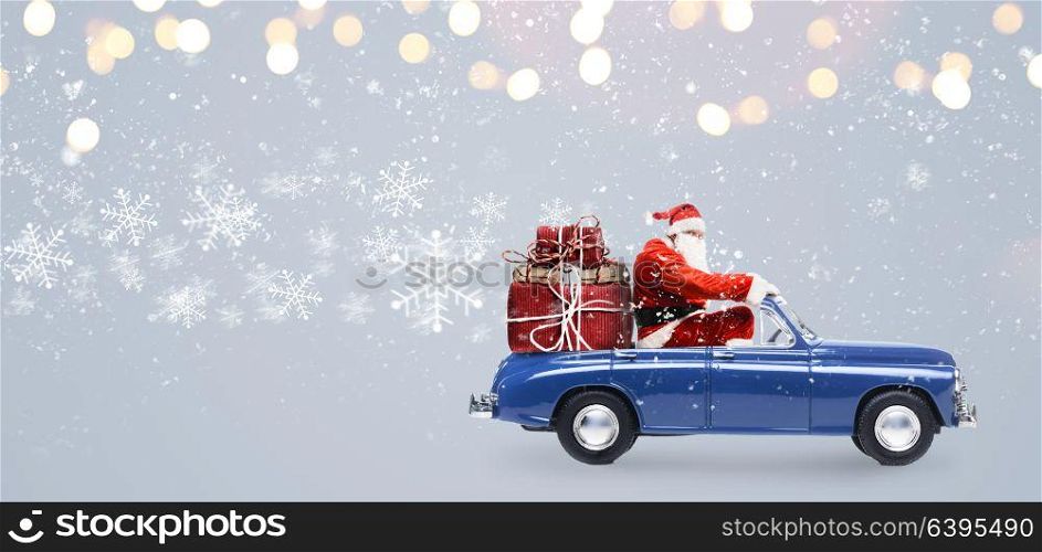 Santa Claus on car. Santa Claus on car delivering Christmas or New Year gifts at snowy gray background
