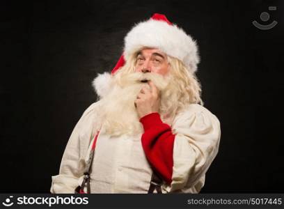 Santa Claus pensive against dark background