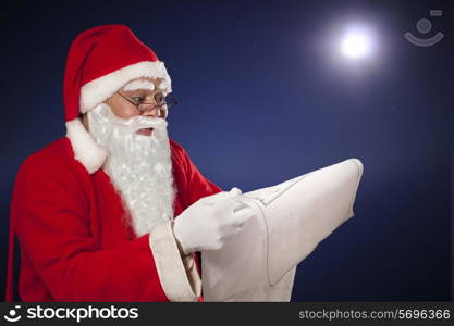 Santa Claus reading list paper with moon in background