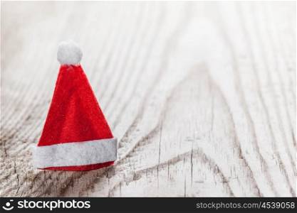 Santa Claus red hat. Small decorative Santa Claus red hat on wooden background