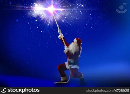 Santa Claus. Santa Claus catching star in night sky with rope