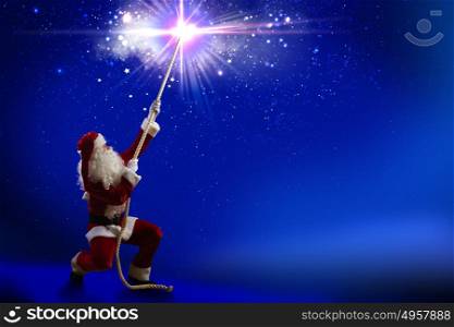 Santa Claus. Santa Claus catching star in night sky with rope