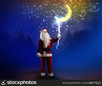 Santa Claus. Santa Claus holding moon in night sky on rope