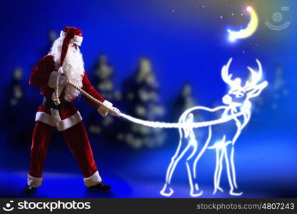Santa Claus. Santa claus looking at magic image of deer