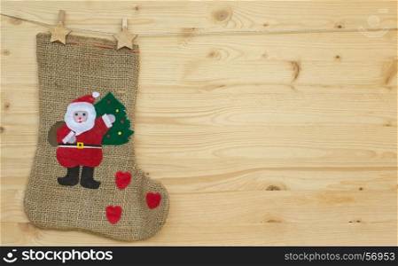 santa claus sock or stocking with clothes pegs on wood