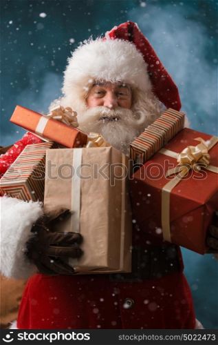 Santa Claus walking on the snow with his sack of lots of presents. Winter night with snowfall