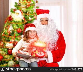 Santa Claus with granddaughter sitting near Christmas tree, cute girl opening gift box, glowing lights, magic night, fairy tale concept