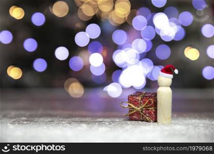 Santa claus with red Christmas gift box on wooden table with bokeh background and copy space, Merry Christmas,holiday,present concept space for text. Santa claus with red Christmas gift box on wooden table with bokeh background and copy space, Merry Christmas,holiday,present concept