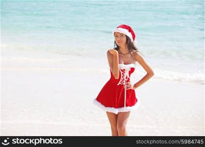 Santa Claus woman on beach. Woman wearing santa claus stylized dress posing on beach