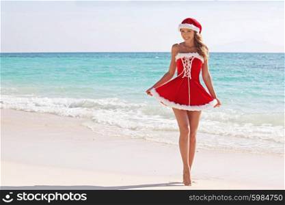 Santa Claus woman on beach. Woman wearing santa claus stylized dress posing on beach
