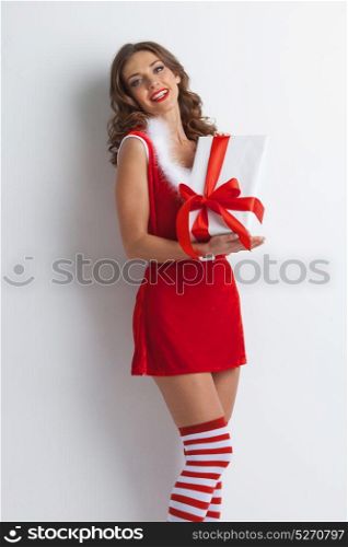 Santa Claus woman with gift. Beautiful woman in Santa Claus style dress with gift box