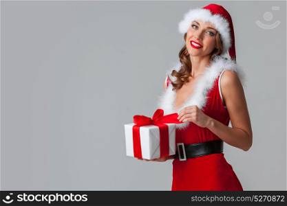 Santa Claus woman with gift. Beautiful woman in Santa Claus style dress with gift box