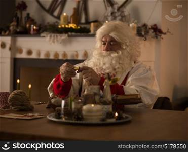 Santa Claus Working at Home. Repairing his Gloves