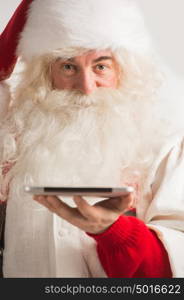 Santa Claus working on tablet computer closeup portrait