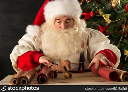 Santa Claus working - preparing and wrapping christmas gifts, toys before sending it to children