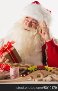 Santa Claus working - preparing and wrapping christmas gifts, toys before sending it to children