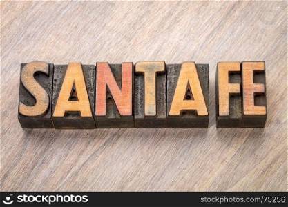 Santa Fe word abstract in vintage letterpress wood type against grained wooden background