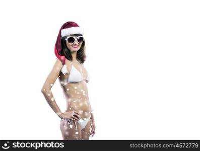 Santa girl. Attractive girl in Santa hat and white bikini against color background