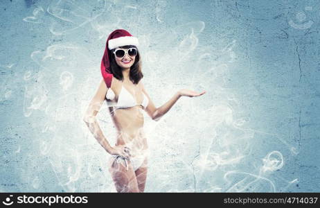 Santa girl. Attractive girl in Santa hat and white bikini against color background