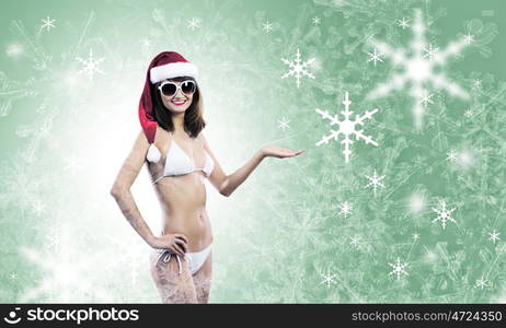 Santa girl. Attractive girl in Santa hat and white bikini against color background