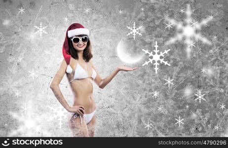 Santa girl. Attractive girl in Santa hat and white bikini against color background