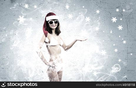 Santa girl. Attractive girl in Santa hat and white bikini against color background