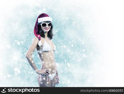 Santa girl. Attractive girl in Santa hat and white bikini against color background